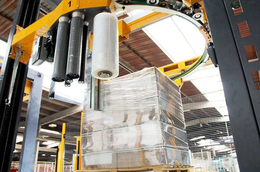 Machine wrapping pallet with plastic film.